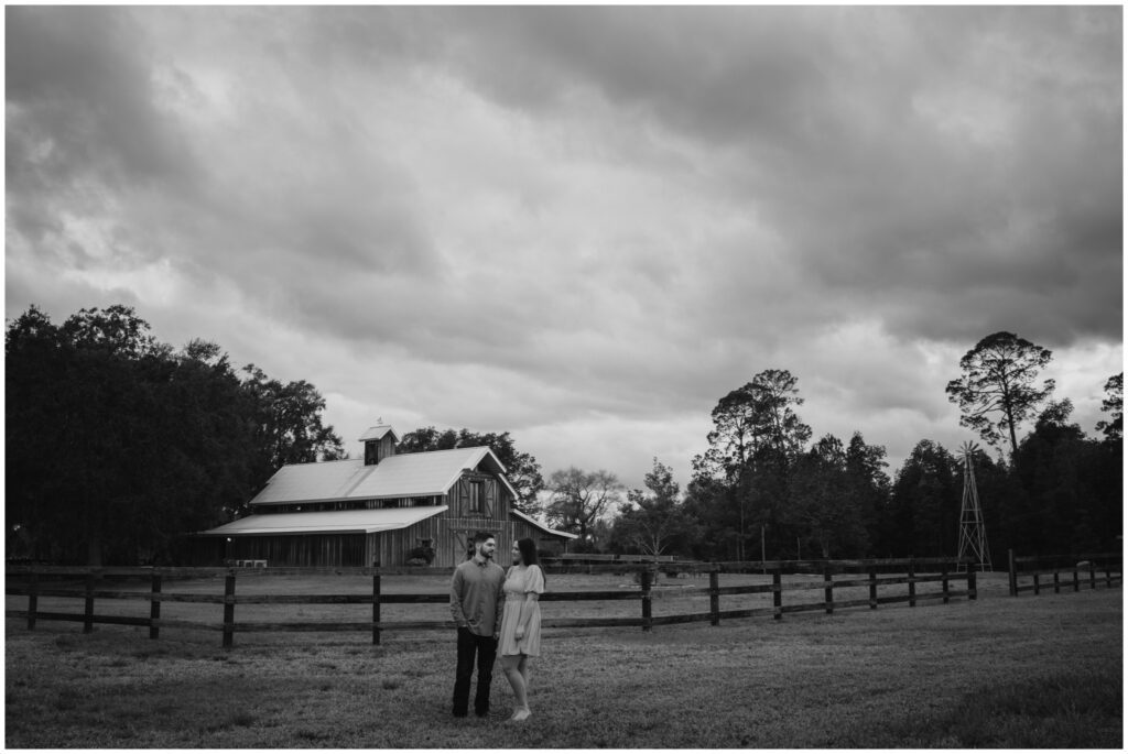 image of an Engagement portrait in front of a barn by Coastal Chic Studios