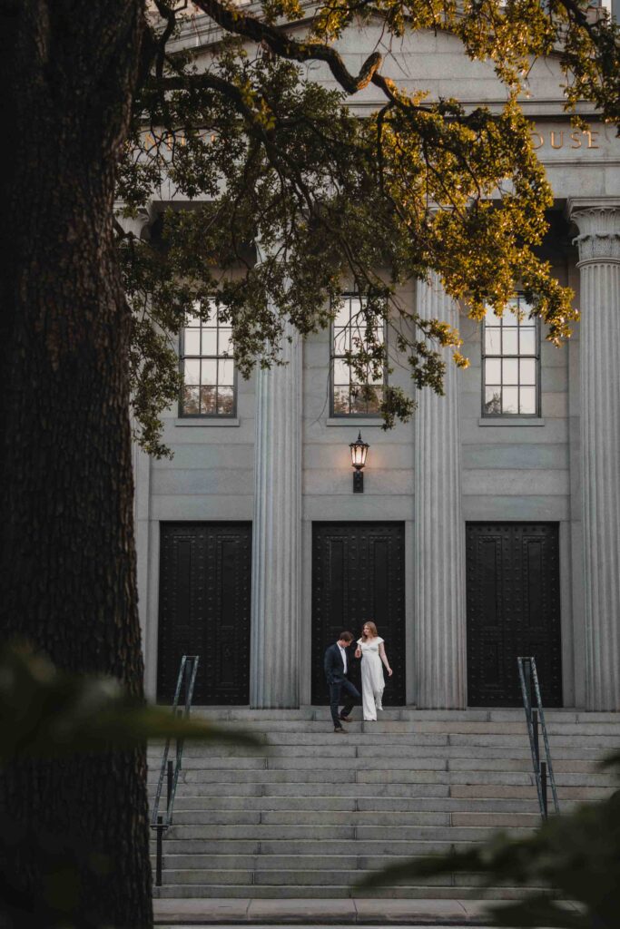 Couple walking down steps at the U.S. Customs House in Savannah GA during an engagement session.