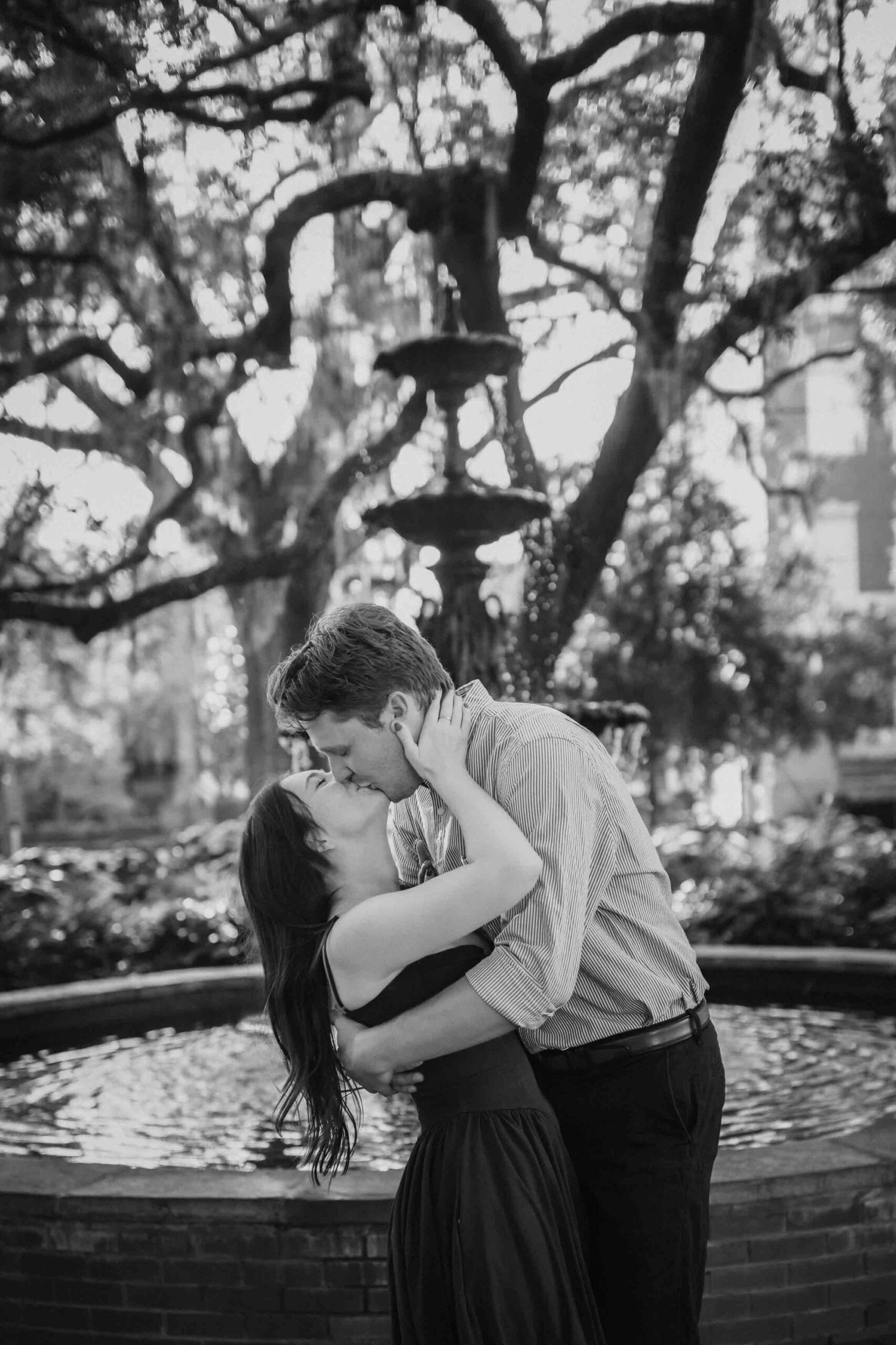 Surprise proposal at Lafayette Square fountain in Savannah captured by Coastal Chic Studios engagement photographer at sunset