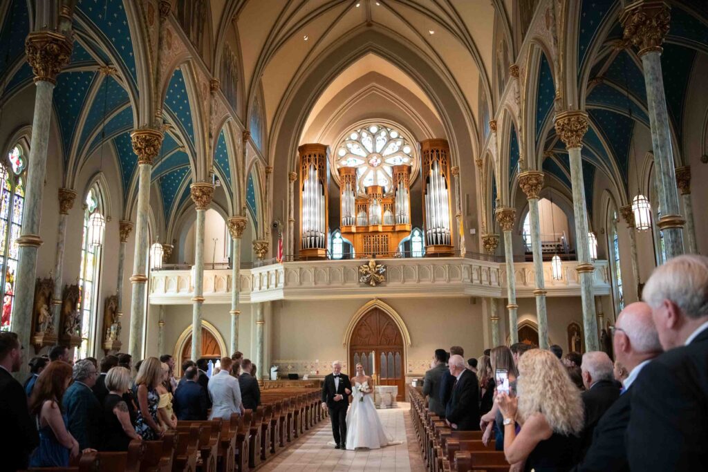 A Savannah bride walks toward her groom for their First Look outside The Cathedral Basilica of St. John the Baptist.